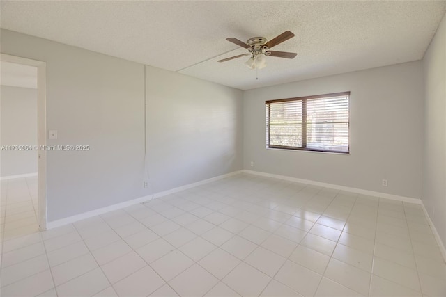 spare room with ceiling fan, light tile patterned floors, and a textured ceiling