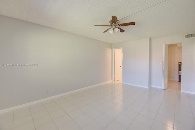 unfurnished room featuring ceiling fan, light tile patterned flooring, and a textured ceiling