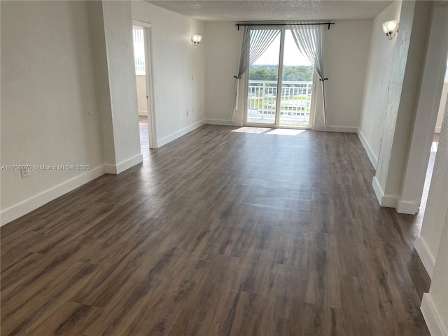 spare room with dark hardwood / wood-style flooring and a textured ceiling