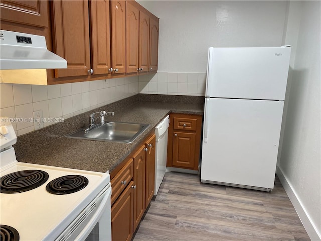 kitchen with white appliances, light hardwood / wood-style floors, sink, and decorative backsplash