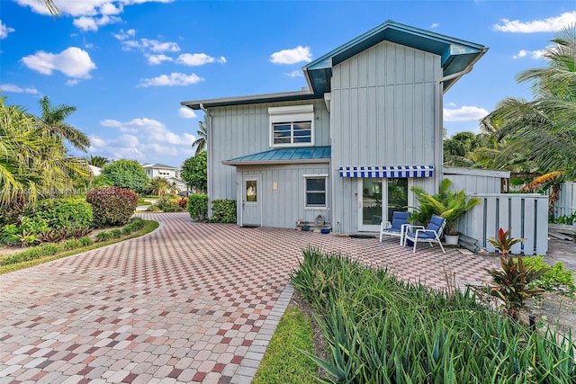 rear view of house featuring a patio area and board and batten siding