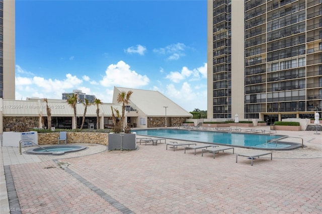 view of swimming pool with a hot tub and a patio area