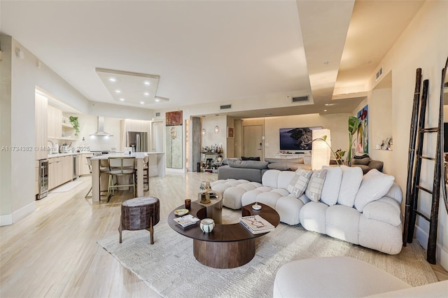 living room with wine cooler and light hardwood / wood-style floors