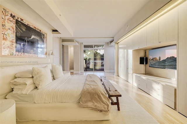 bedroom featuring access to exterior and light wood-type flooring