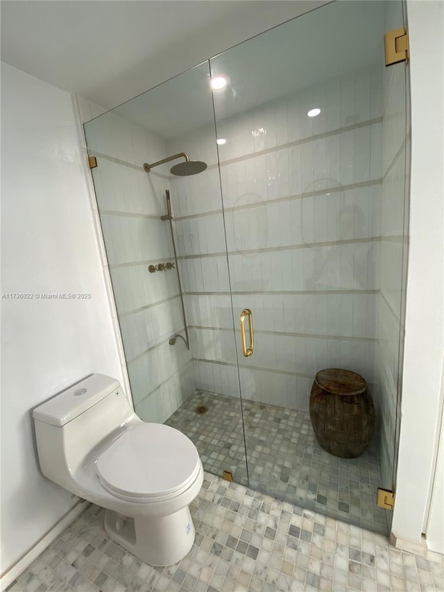 bathroom featuring toilet and an enclosed shower