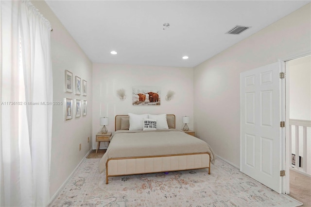 bedroom with baseboards, visible vents, light colored carpet, and recessed lighting