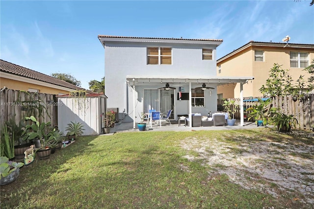 back of property with a lawn, ceiling fan, a fenced backyard, a patio area, and an outdoor living space