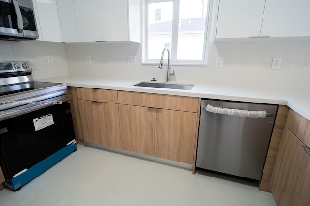 kitchen featuring white cabinetry, stainless steel appliances, sink, and decorative backsplash