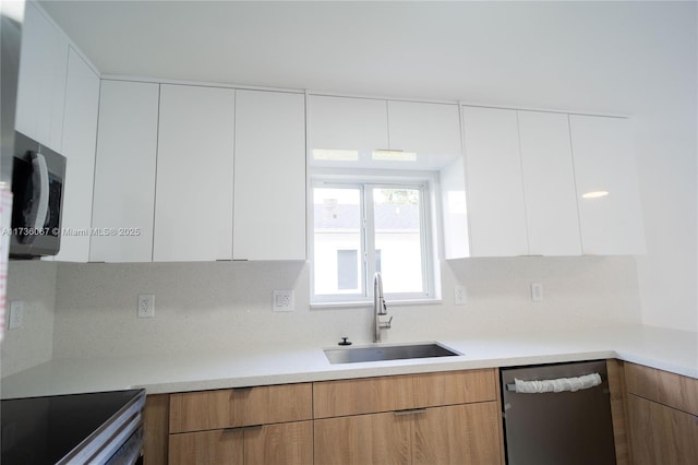 kitchen featuring white cabinetry, sink, and appliances with stainless steel finishes