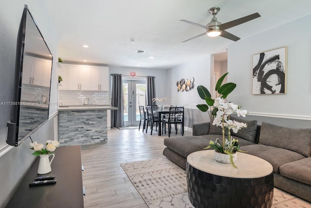 living room featuring light hardwood / wood-style flooring and ceiling fan