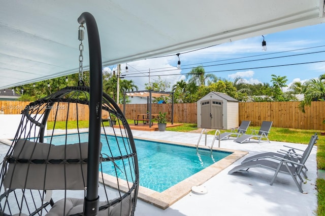 view of swimming pool featuring a patio and a shed