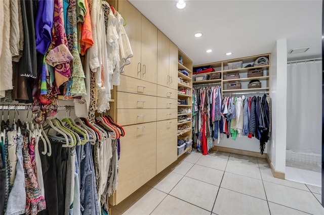 walk in closet with light tile patterned floors