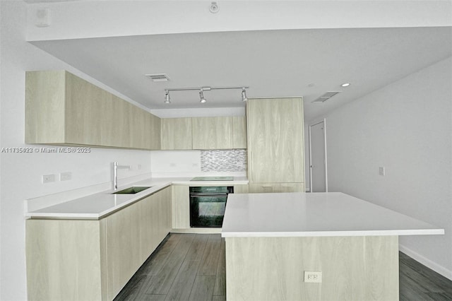 kitchen featuring sink, light brown cabinets, black appliances, and a kitchen island