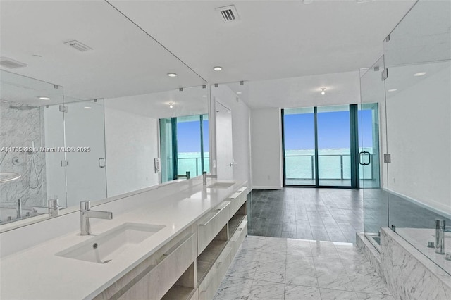 bathroom featuring expansive windows, vanity, and separate shower and tub