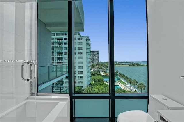 bathroom featuring vanity, separate shower and tub, and a water view