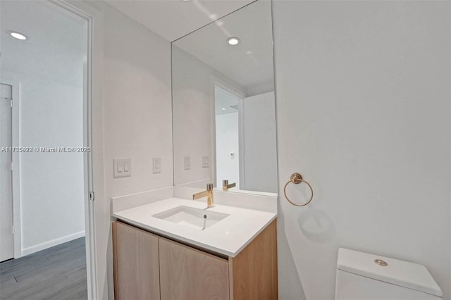 bathroom with vanity, hardwood / wood-style floors, and toilet