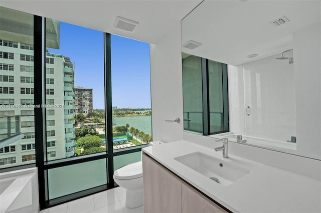 full bathroom with tile patterned floors, toilet, a water view, shower with separate bathtub, and vanity