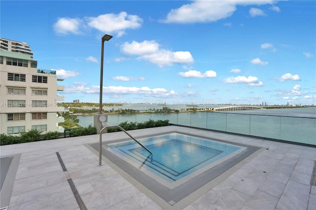 view of pool featuring a patio area and a water view