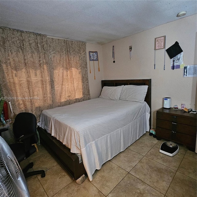 bedroom with light tile patterned floors and a textured ceiling