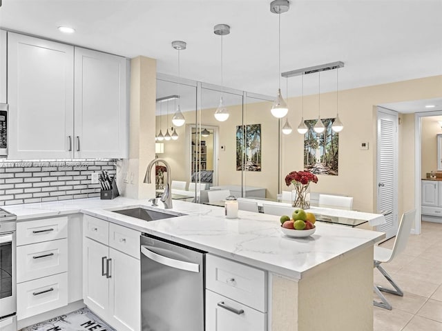 kitchen featuring appliances with stainless steel finishes, sink, white cabinets, and kitchen peninsula