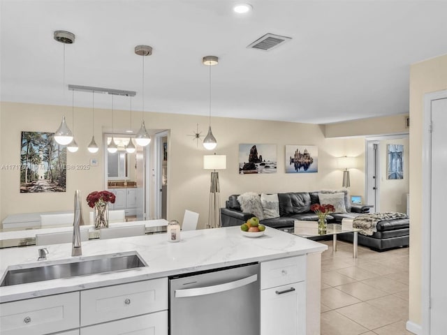 kitchen with sink, hanging light fixtures, light tile patterned floors, stainless steel dishwasher, and white cabinets