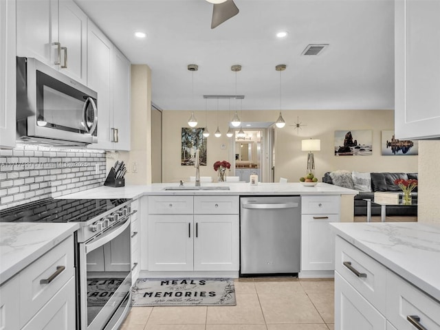 kitchen featuring stainless steel appliances, white cabinets, and decorative light fixtures