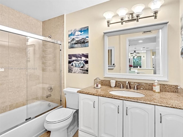 full bathroom featuring enclosed tub / shower combo, vanity, and toilet