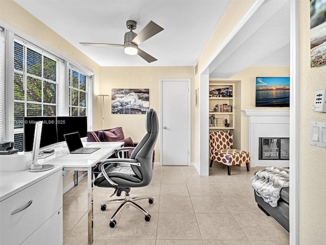 tiled home office featuring ceiling fan