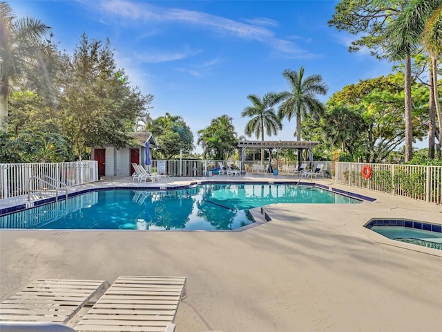 view of swimming pool featuring a hot tub and a patio