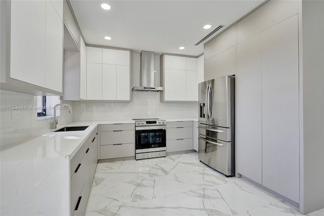 kitchen featuring sink, white cabinets, backsplash, stainless steel appliances, and wall chimney exhaust hood