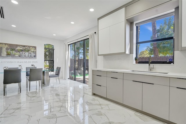 kitchen featuring white cabinetry and sink