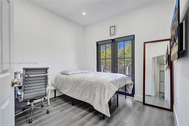 bedroom with hardwood / wood-style floors, access to outside, and french doors