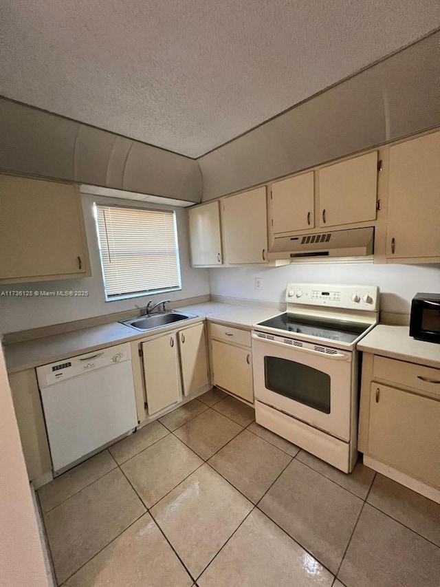 kitchen featuring white appliances, cream cabinetry, sink, and light tile patterned floors