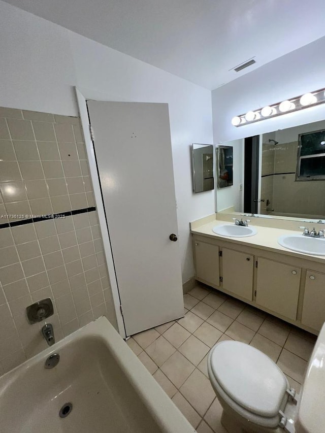 full bathroom featuring tile patterned flooring, vanity, toilet, and tiled shower / bath