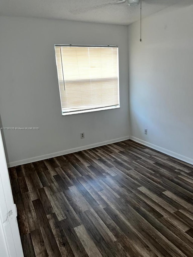 empty room featuring dark hardwood / wood-style flooring and a textured ceiling