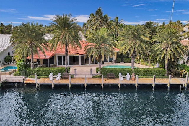 exterior space featuring a pool, a patio, and a water view