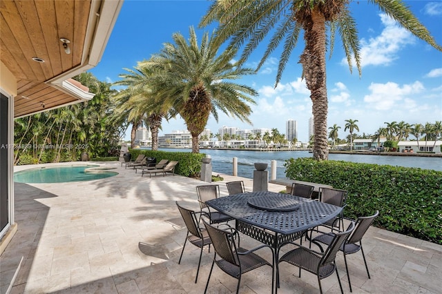 view of patio / terrace with outdoor dining space, a water view, and an outdoor pool