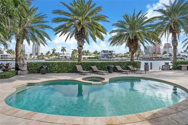 view of swimming pool featuring a pool with connected hot tub and a city view