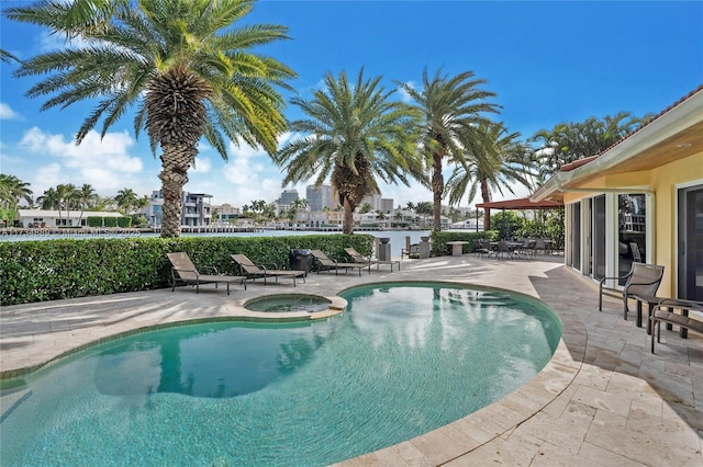 view of swimming pool featuring a patio and an in ground hot tub