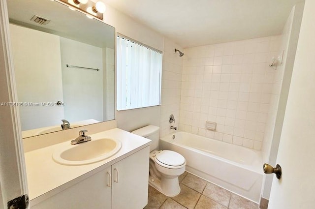 full bathroom featuring vanity, tile patterned floors, toilet, and tiled shower / bath