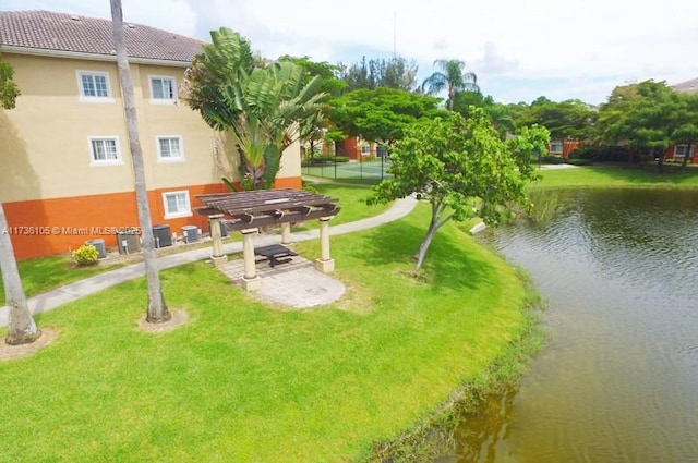 view of home's community with a pergola, a yard, and a water view