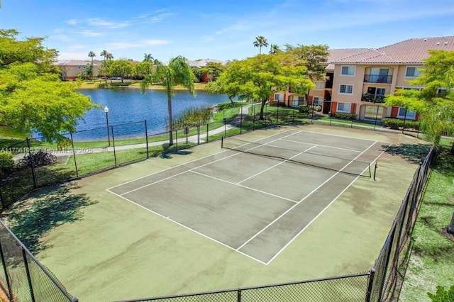 view of tennis court with a water view