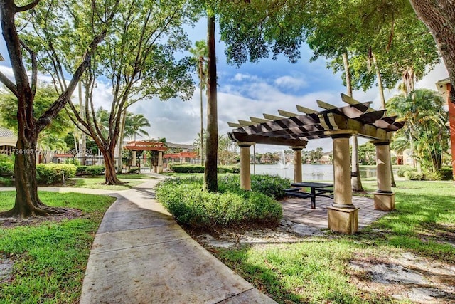 surrounding community with a yard and a pergola