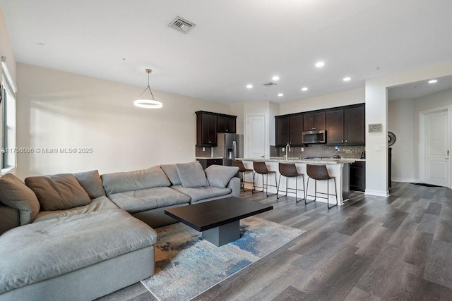 living room with sink and dark hardwood / wood-style floors