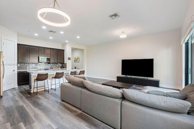 living room featuring dark hardwood / wood-style flooring and sink