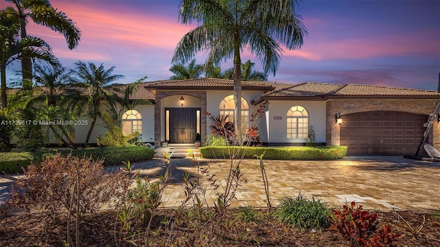 mediterranean / spanish-style house with a garage