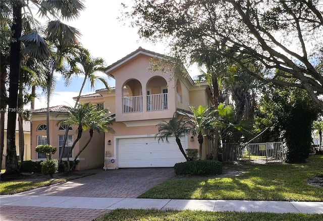 mediterranean / spanish-style house with a balcony, a garage, and a front lawn