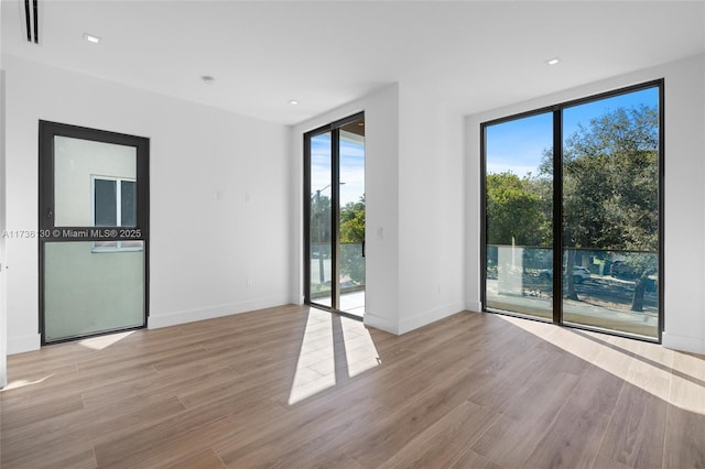 unfurnished room featuring a healthy amount of sunlight and light wood-type flooring