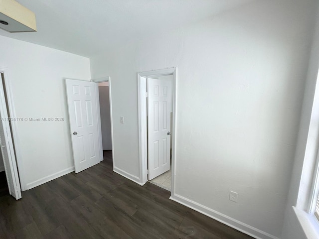 unfurnished bedroom with dark hardwood / wood-style flooring