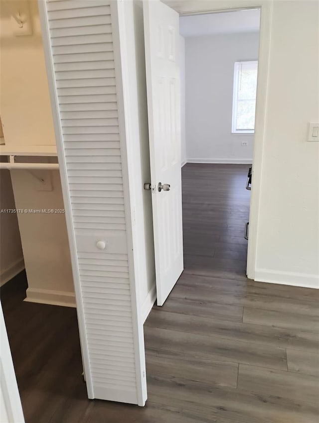 hallway with baseboards and wood finished floors